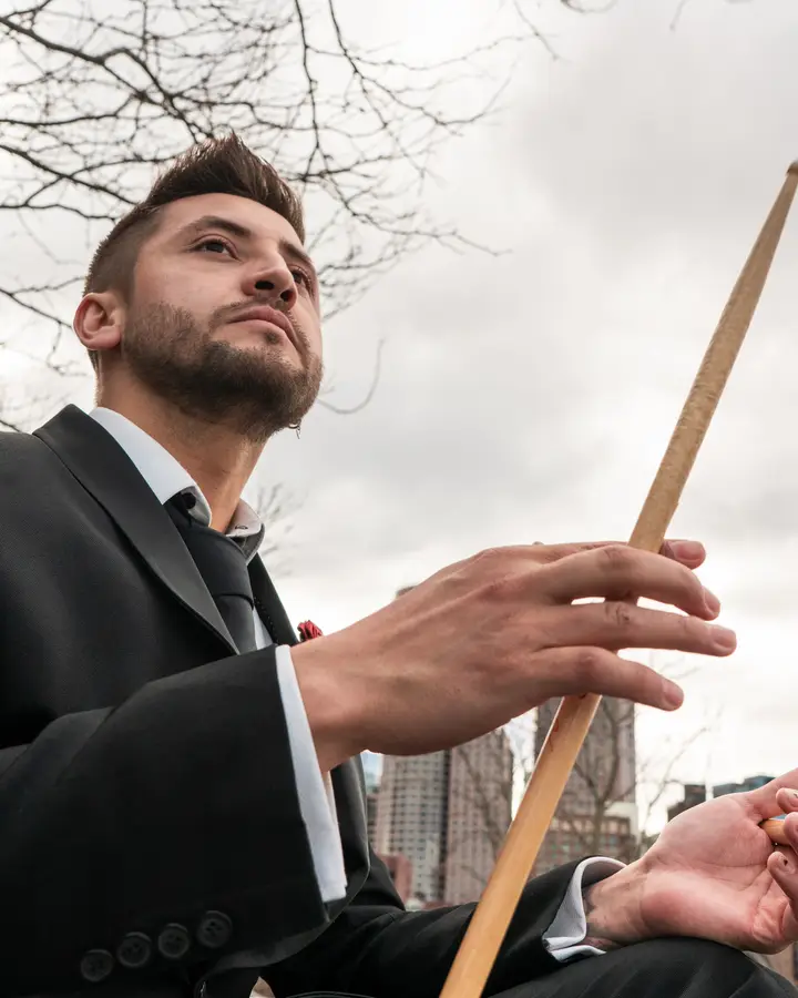 Nicko Guerrero con una baqueta frente al cielo de Boston