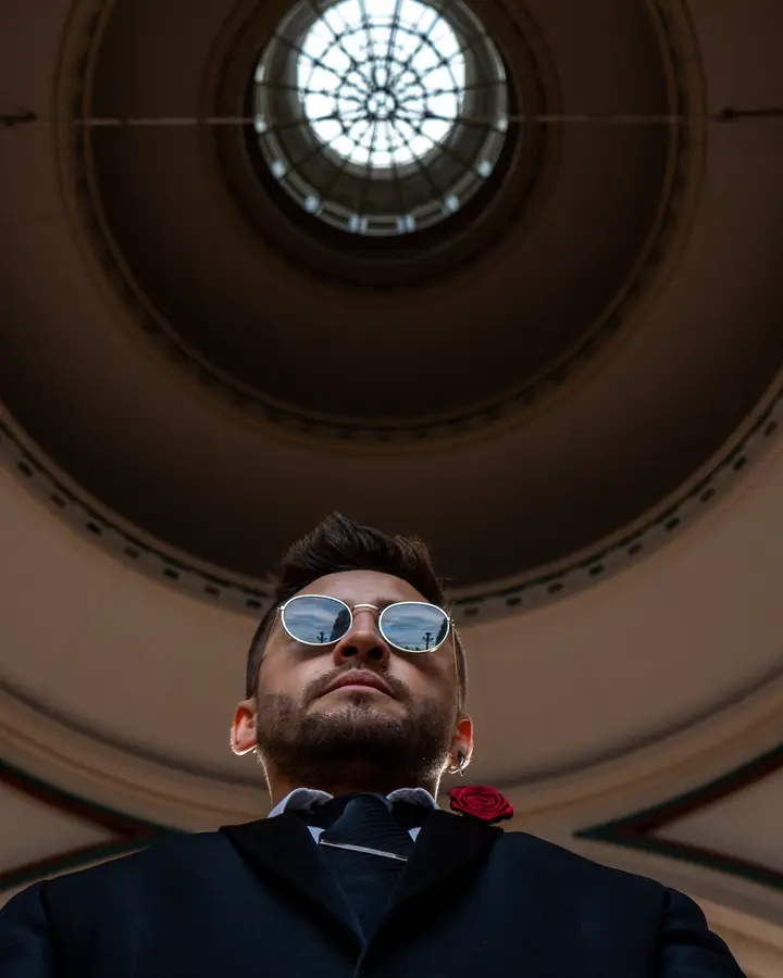 Nicko Guerrero con abrigo de piel frente a un muro de boyas